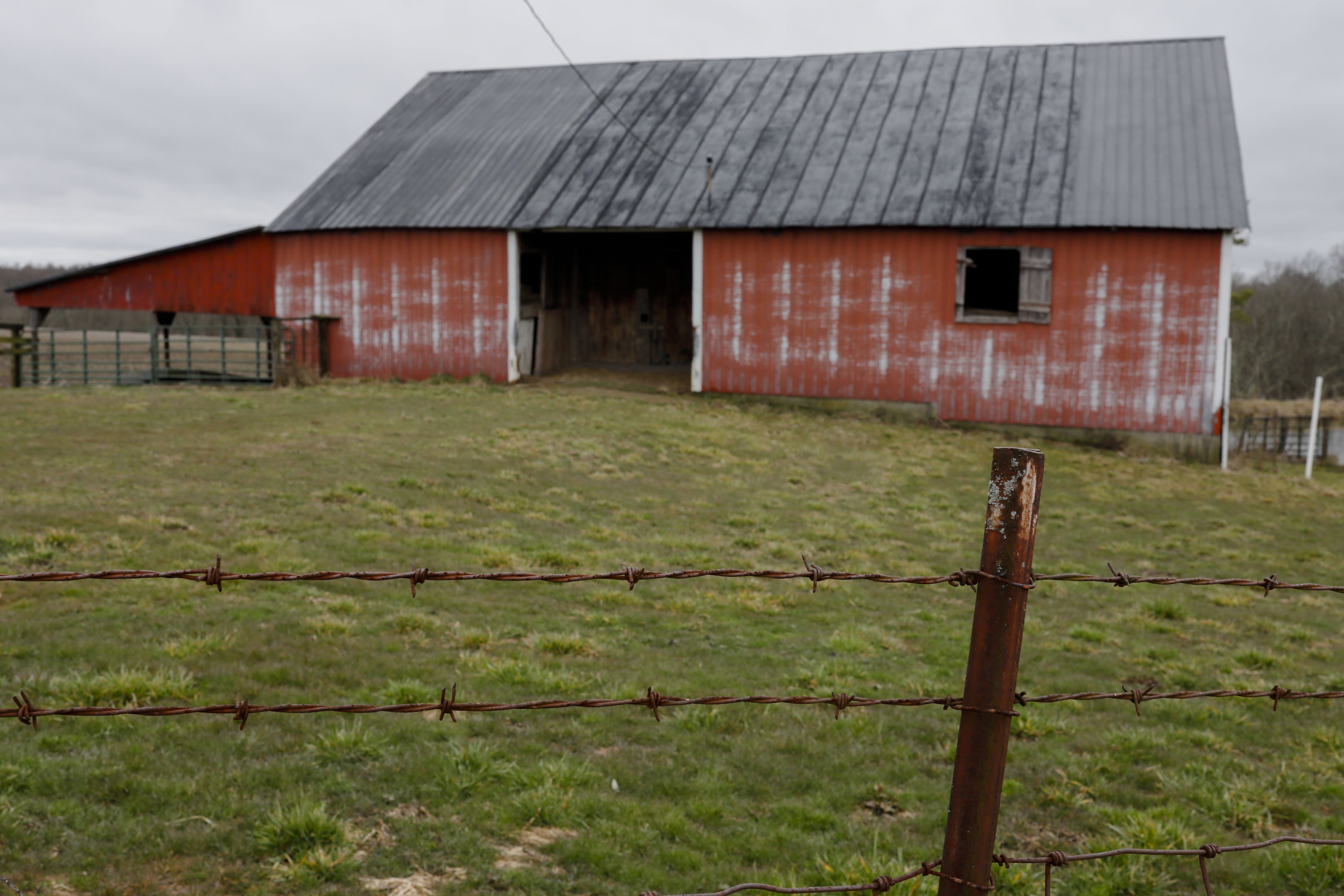 A barbed wire fence surrounds an old barn where Charlie Utter's cousin once kept angus cattle on Tuesday, March 3, 2020 in Georgetown, Ohio. His cousin died by suicide in July 2017 and Charlie was left to handle his affairs after his death. [Joshua A. Bickel/Dispatch]