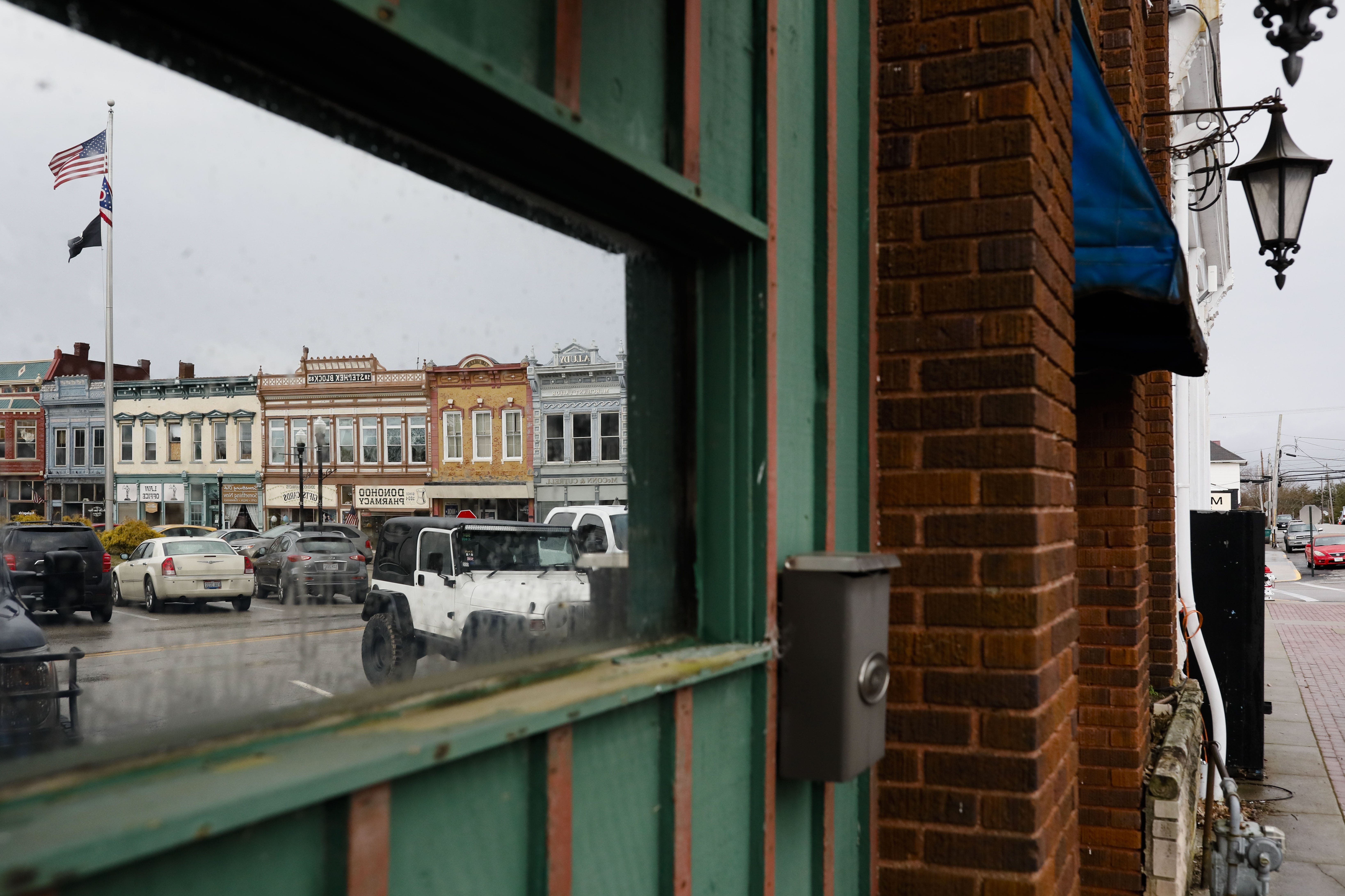 Buildings on the town square are reflected in a windown on Tuesday, March 3, 2020 in Georgetown, Ohio. [Joshua A. Bickel/Dispatch]