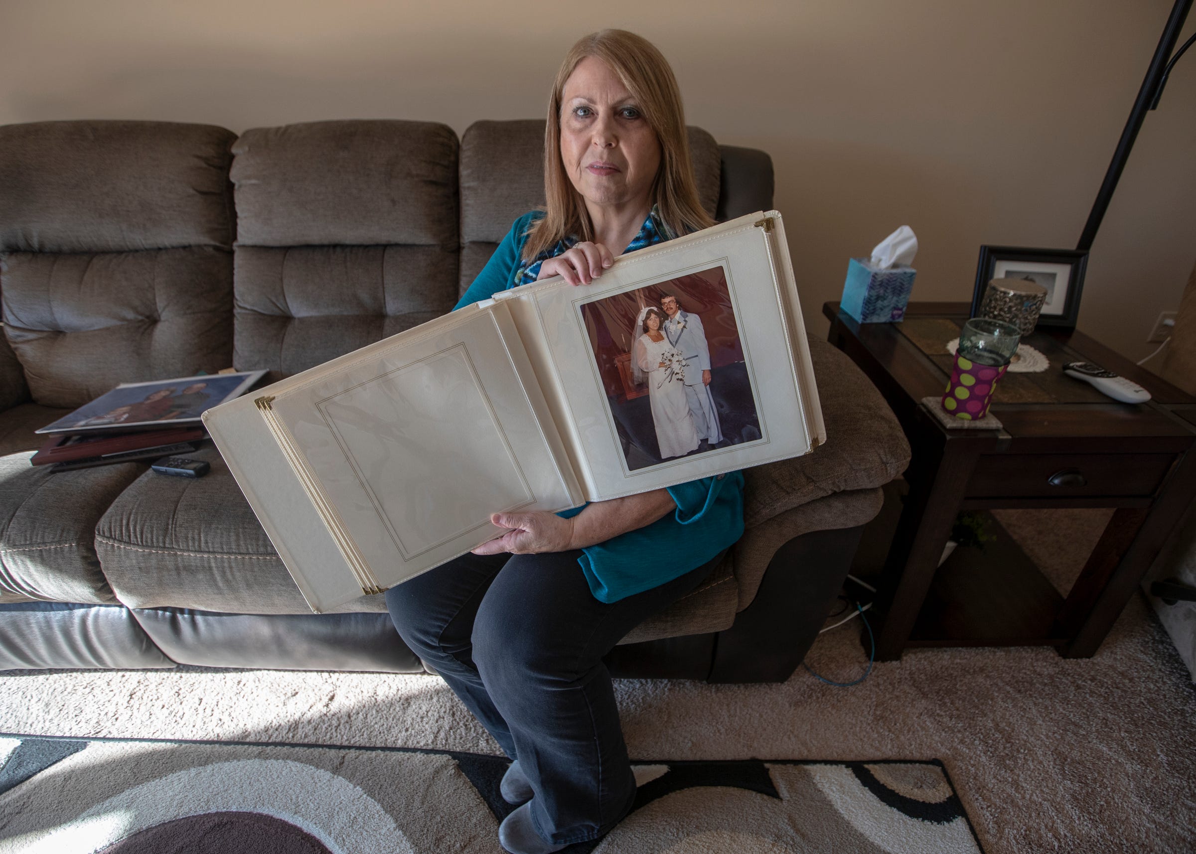 Cathy King holds an album of wedding pictures with her husband, Greg Robinson, on Dec. 4, 2019. Robinson died in 2015 after complications that allegedly arose from improper care.