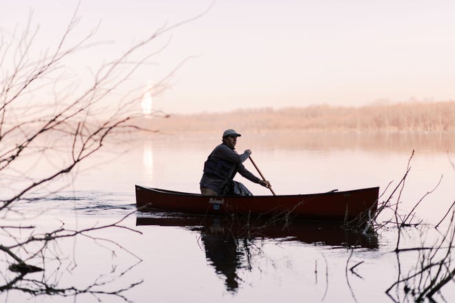 John Naylor paddles his canoe near Wrightsville, Pa., looking for plastics to pull from the Susquehanna River.