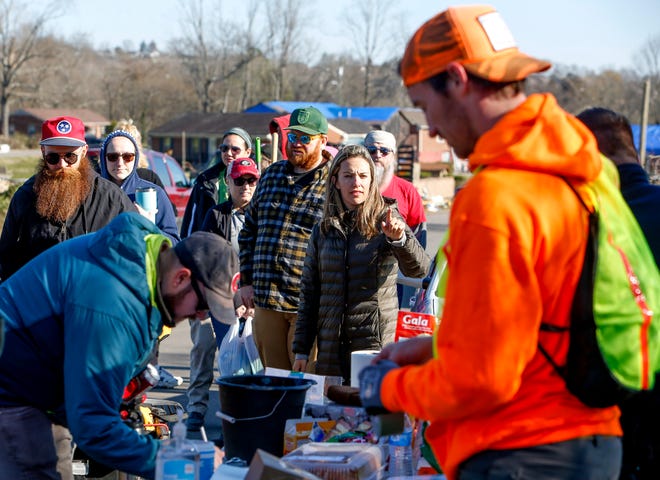 Volunteers line up for assignments and to get spare equipment before they have to work at the Donford Stanford Estates Subdivision in Nashville, Tennessee, Saturday March 7, 2020.