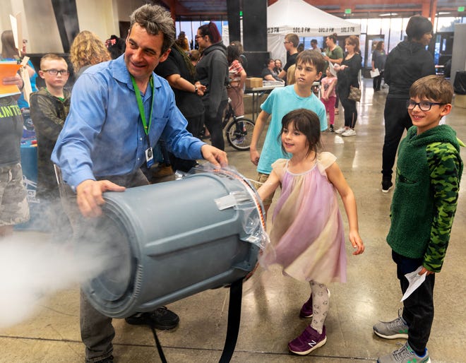 Emmeline Nomicos, 6, from Cottonwood Elementary, shoots fog with some help from Nathan Tobey at the Fernley High School STEM Festival.
