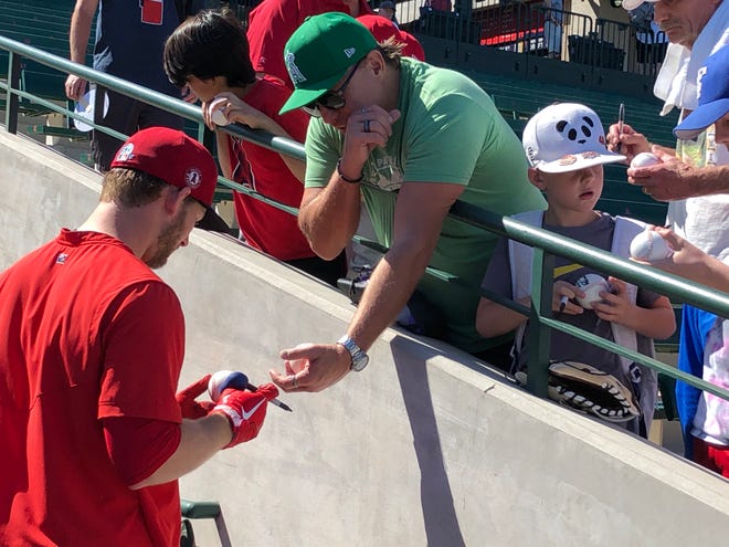Angels' public service Taylor Ward signs autographs for fans at the Tempe Diablo Stadium on Saturday.