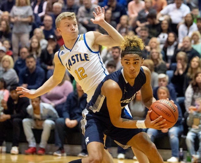 Reitz's Khristian Lander (4) is guarded by Castle's Jackson Mitchell in the Panthers' 69-61 victory on March 7 in the Class 4A North Sectional championship game.