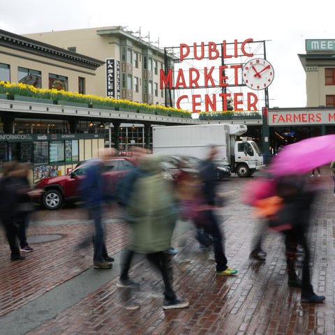 Tourists walk past the Public Market Center sign i
