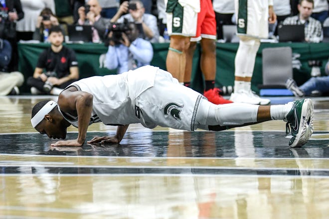 Michigan State's Cassius Winston kisses the floor before checking out during the second half on Sunday, March 8, 2020, at the Breslin Center in East Lansing.