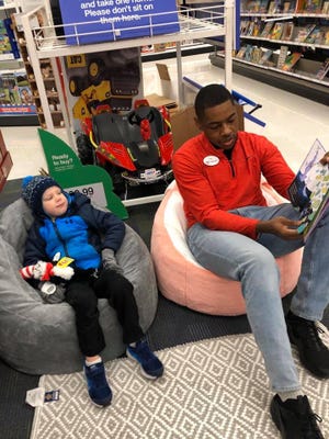 Trey Hawthorne, a 20-year-old employee at Target in Brookfield, is seen here reading a Dr. Seuss book to a child during Target's celebration of National Read Across America Day.