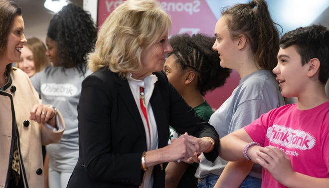 Former second lady Jill Biden, middle, and Michigan Gov. Gretchen Whitmer, left, elbow bump youngsters Tuesday, March 10, 2020, before a tour and chat at the Think Tank at Impression 5 Science Center in downtown Lansing, Mich.