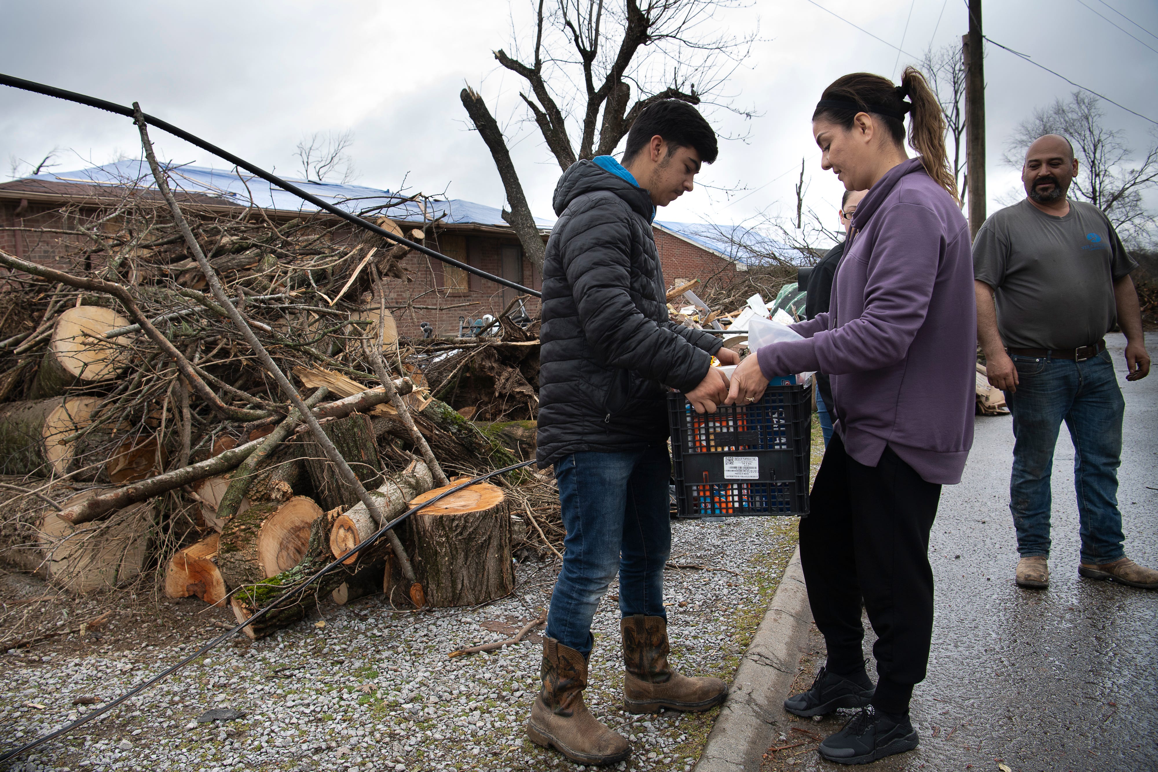 Oscar Cruz takes food supplies from volunteer Jeannette Castro outside his home along Quail Dr.  Tuesday, March 10, 2020 in Nashville, Tenn. The Cruz family is trying to rebuild their home after a tornado ripped through their neighborhood last week. 