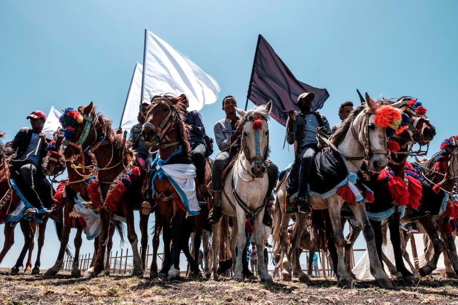 Horsemen hold black and white flags during a memorial ceremony at the crash site of the Ethiopian Airlines Flight 302 airplane accident in Tulu Fara, Ethiopia, on March 8, 2020. Ethiopian Airlines Flight 302 crashed southeast of Addis Ababa on March 10, 2019, killing 157 people.