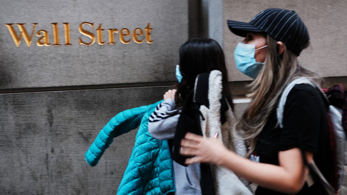 People walk by the New York Stock Exchange (NYSE) on March 9, 2020 in New York City. The Dow Jones Industrial Average fell more than 2,000 points as investors concerns over the spreading coronavirus continue to affect global markets.