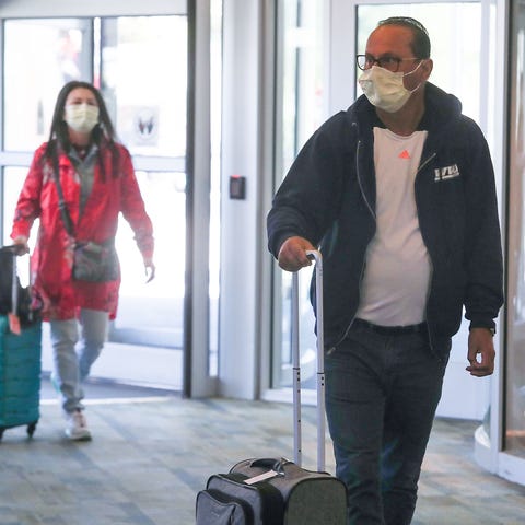 Travelers wearing masks enter Palm Springs Interna