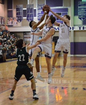 San Saba High School's Risien Shahan (12) watches his teammates Sean O'Keefe (left) and Logan Glover (21) try to haul in a rebound against Normangee during the Region IV-2A championship game Saturday, March 8, 2020, at the Snake PIt at San Marcos High School.