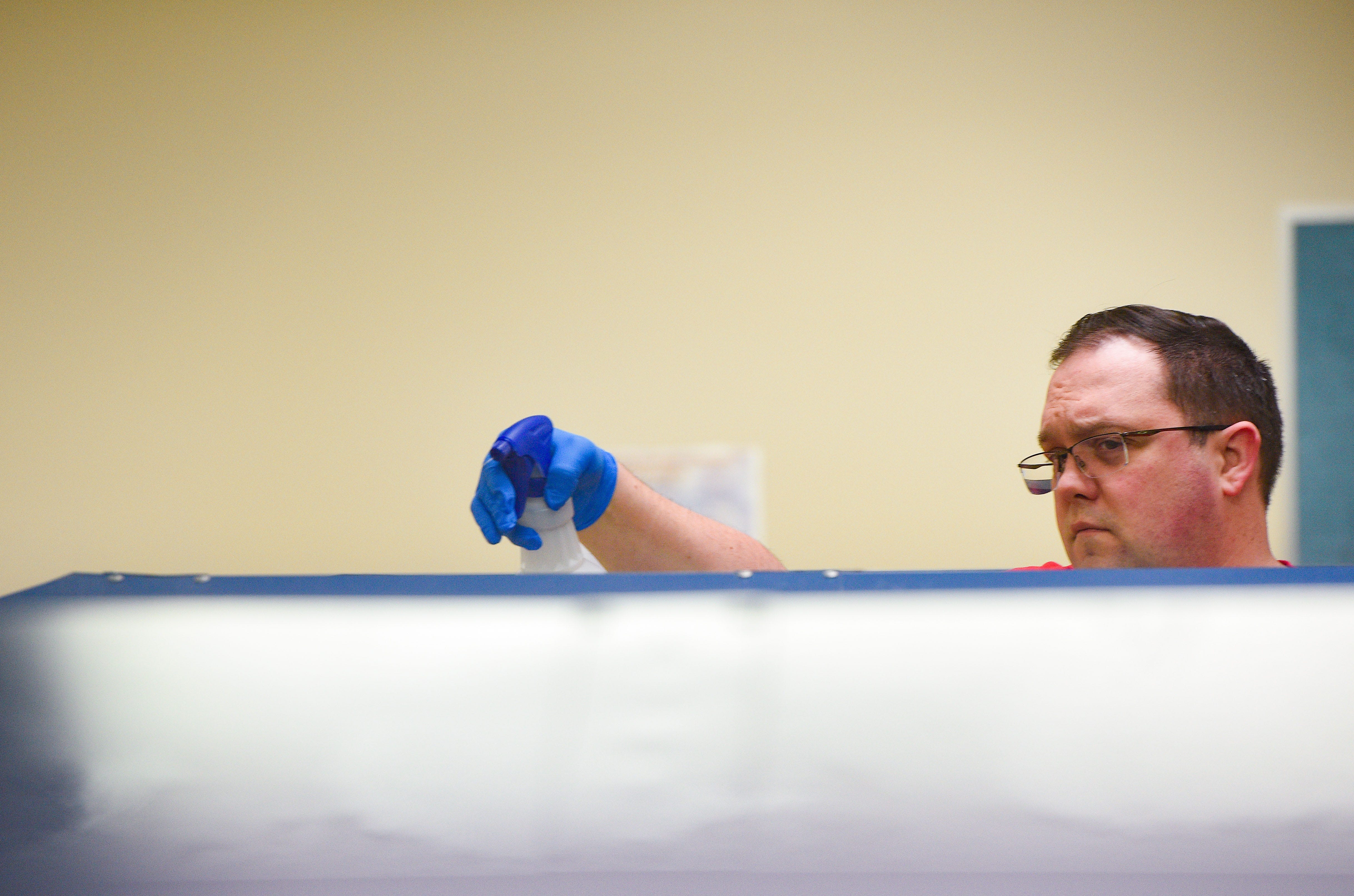 Custodian Craig Kuca cleans lockers at West Central High School on Wednesday, March 11, in Hartford.