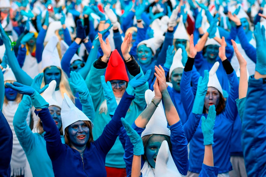 People dressed as Smurfs, a Belgian comic franchise centered on a fictional colony of small, blue, human-like creatures who live in mushroom-shaped houses in the forest, attend a world record gathering of Smurfs on March 7, 2020, in Landerneau, western France.