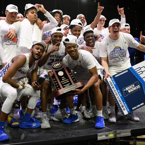 Hofstra players pose with the trophy after they wo