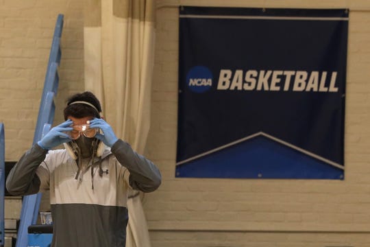 Taylor Michel, director of operations of the Disinfecting Technologies Group, prepares to disinfect the arena following an NCAA Division III menu2019s basketball game at Goldfarb Gymnasium at Johns Hopkins University last Friday in Baltimore, Md. On Wednesday the NCAA announced the tournament would be closed to fans.