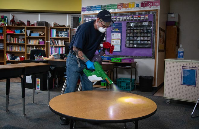 Robert Truman (SSC Services for Education) uses an electrostatic sprayer to sanitize a classroom, March 12, 2020, at Kyrene de la Mirada Elementary School, 5500 W Galveston St., Chandler.