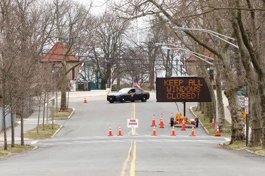A New York State Trooper blocks the entrance to Glen Island Park in New Rochelle, NY, where a sign warns people to keep windows closed March 12, 2020. Preparations are underway to transform the park to a coronavirus testing area.