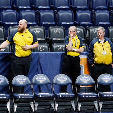 Security guards stand behind a team bench area at 