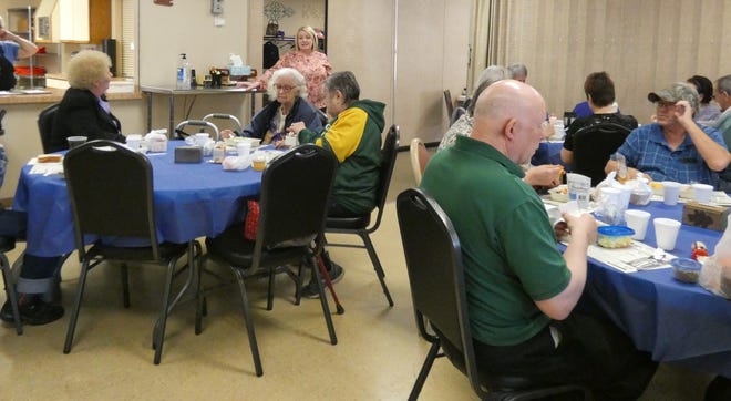 Cassie Herschler, standing at rear, explains to seniors dining at the Crawford County Council on Aging on Friday, March 13, 2020, that while the center had canceled all activities indefinitely, the daily congregate meals would continue. (Ultimately, they did not.)