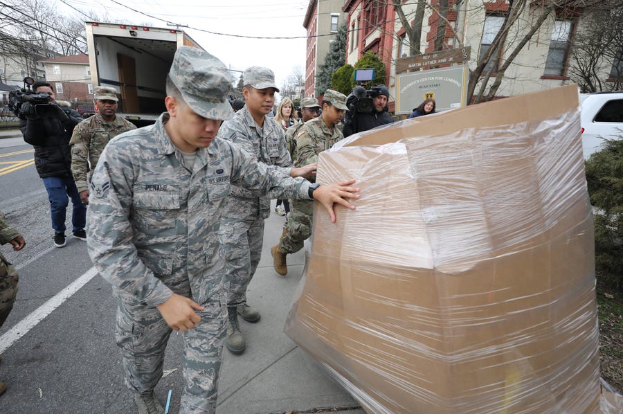 Members of the New York Air and Army National Guard move a pallet of bananas that was unloaded from a Feeding Westchester truck at the New Rochelle Community Action Partnership, at the WestCOP building in New Rochelle, March 12, 2020.