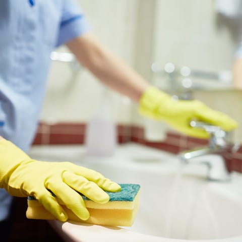 Janitor cleaning sink in hotel room