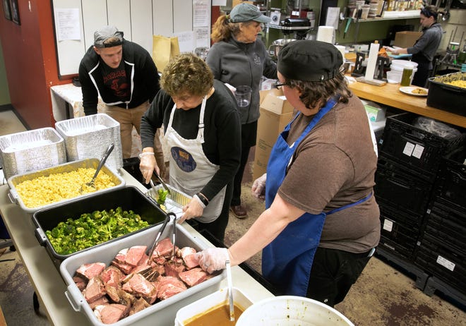 Suzy DeYoung, executive director and founder, with hat, and her team at La Soupe have been rescuing food and feeding those in need since 2014. With Cincinnati Public Schools closed due to the coronavirus, DeYoung jumped into action to create family meals for families. The team was preparing meals Saturday, March 14, 2020 that include mac and cheese, broccoli and prime rib and au jus, along with a chimichurri sauce. They are also offering turkey and chicken as a protein. (L-R) Wes Fowler, new volunteer, Jeanette Rost, one of the original volunteers and head chef Miranda Maszk. 