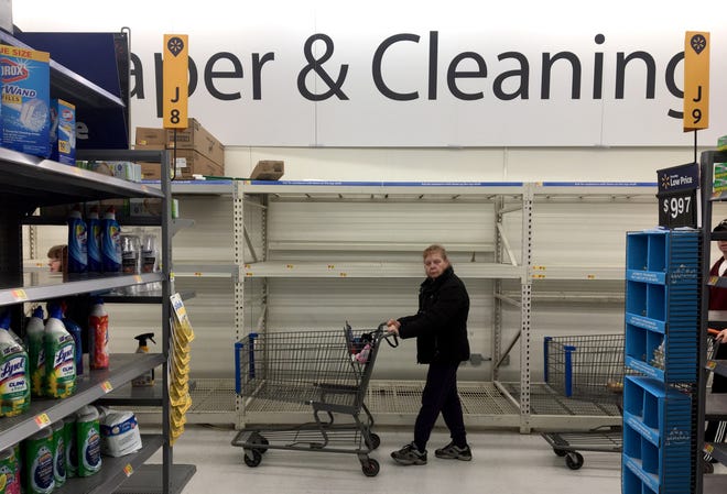 A shopper walks past shelving that was filled with paper products Saturday at Walmart in Fond du Lac.