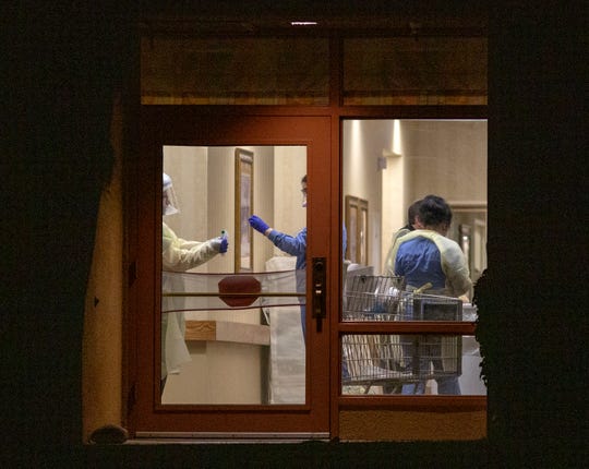 Medical staff at Rancho Mirage Health and Rehabilitation Center wear protective clothing in Rancho Mirage, Calif., on Friday, March 13, 2020. An individual who recently spent time at the nursing facility has tested positive for coronavirus, authorities said Friday.