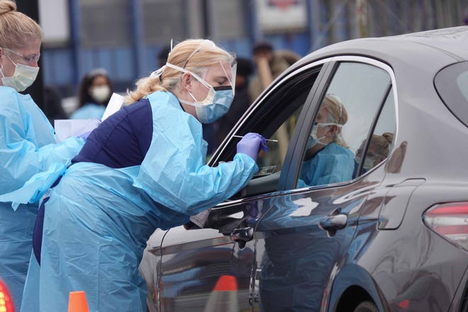 People get tested for the coronavirus at a drive-thru station in Wilmington, Del., on March 13, 2020.