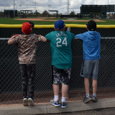 Fans look over the fences of the practice fields a