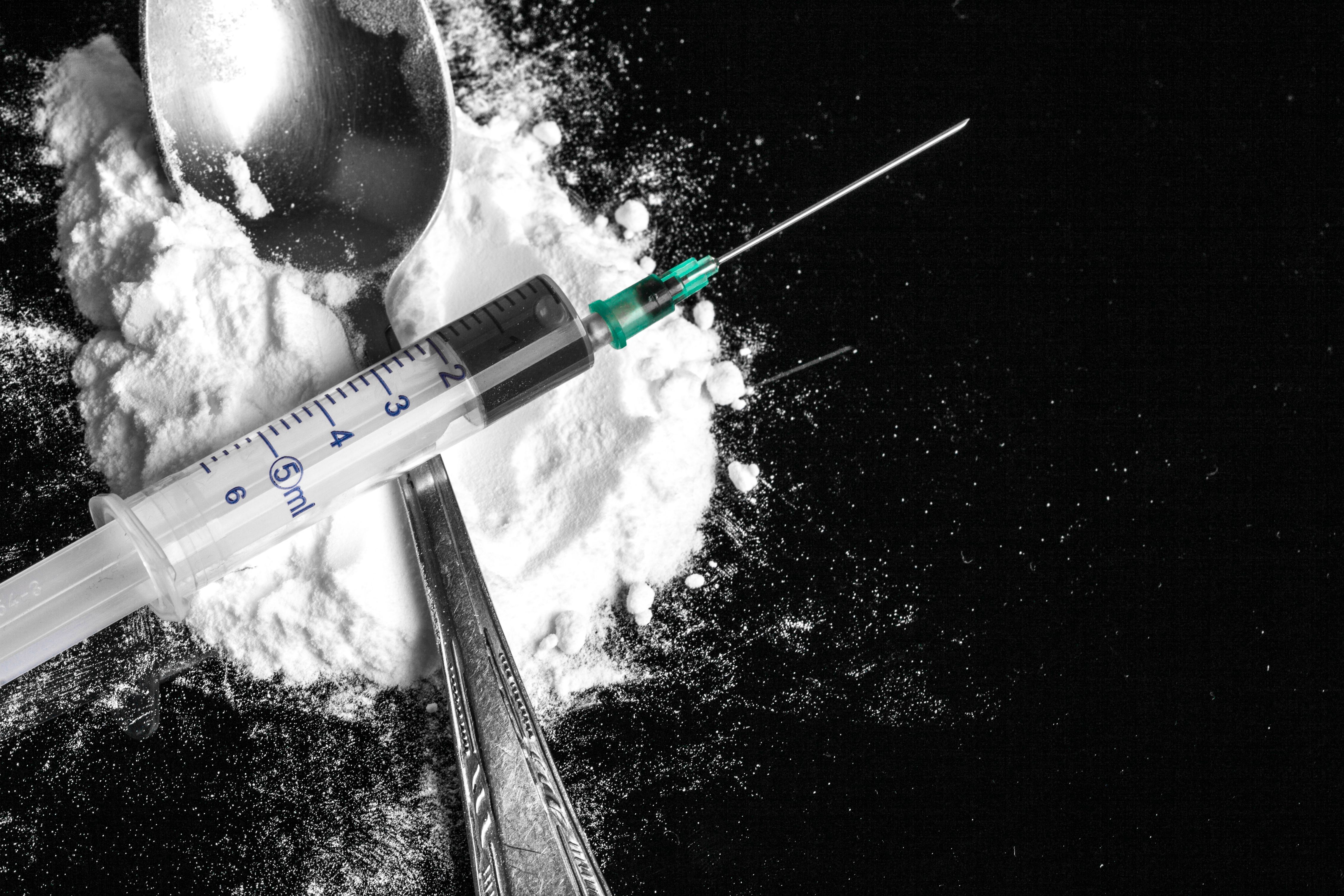 Drug syringe and heroin on spoon