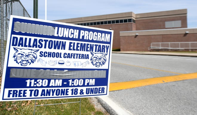 Summer lunch program signs are modified with duct tape to announce the Coronanvirus emergency school lunch program at Dallastown High School Monday, March 16, 2020. The school district is offering grab-n-go meals to students weekdays from 11:30 a.m. to 1 p.m. during the emergency. Bill Kalina photo