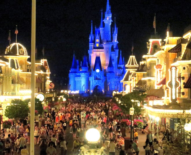 Guests gather on Main Street USA, in the Magic Kingdom at Walt Disney World in the final minutes before the park closed, Sunday night, March 15, 2020, in Lake Buena Vista, Fla.