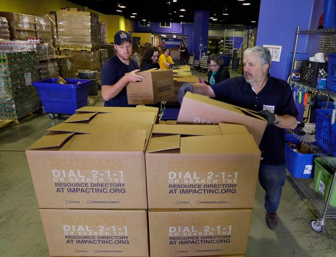 From left, Hunger Task Force workers Chris Bylsma and Bob Brazner load boxes for distribution to more than 10,000 senior citizens in southeast Wisconsin, Tuesday, March 17,2020. Nearly 90% of Hunger Task Force's current network of pantries is voluntary and help is crucial. Small groups of 15-20 are needed to help build Stockboxes.