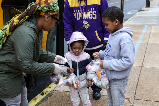 Lavenia Johnson, assistant manager of food services for Red Clay School District, hands meals to Malik (right) and Marvel Massey in front of Warner Elementary during the pandemic in 2020. Families were able to pick up breakfast and lunch bags during the coronavirus shutdown, available to anyone up to age 18.