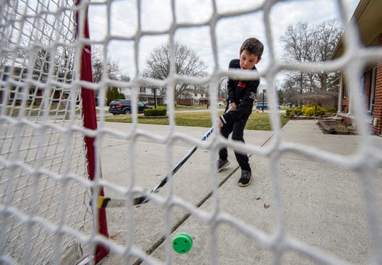 Ian Mearns, 9, practices his shot in front of his home in Grosse Ile. The Meridian Elementary School fourth-grader is a member of the 2010 Belle Tire Bombers hockey team and was trying to get in some practice after his season was postponed due to the coronavirus pandemic.