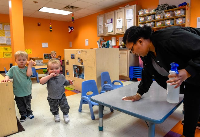 Selena Williams wipes a table down in he one-year-old room at Kidz World daycare as, by executive order issued by the Governor all Kentucky daycare centers will have to close by Friday due to the coronavirus pandemic Wednesday, March 18, 2020.