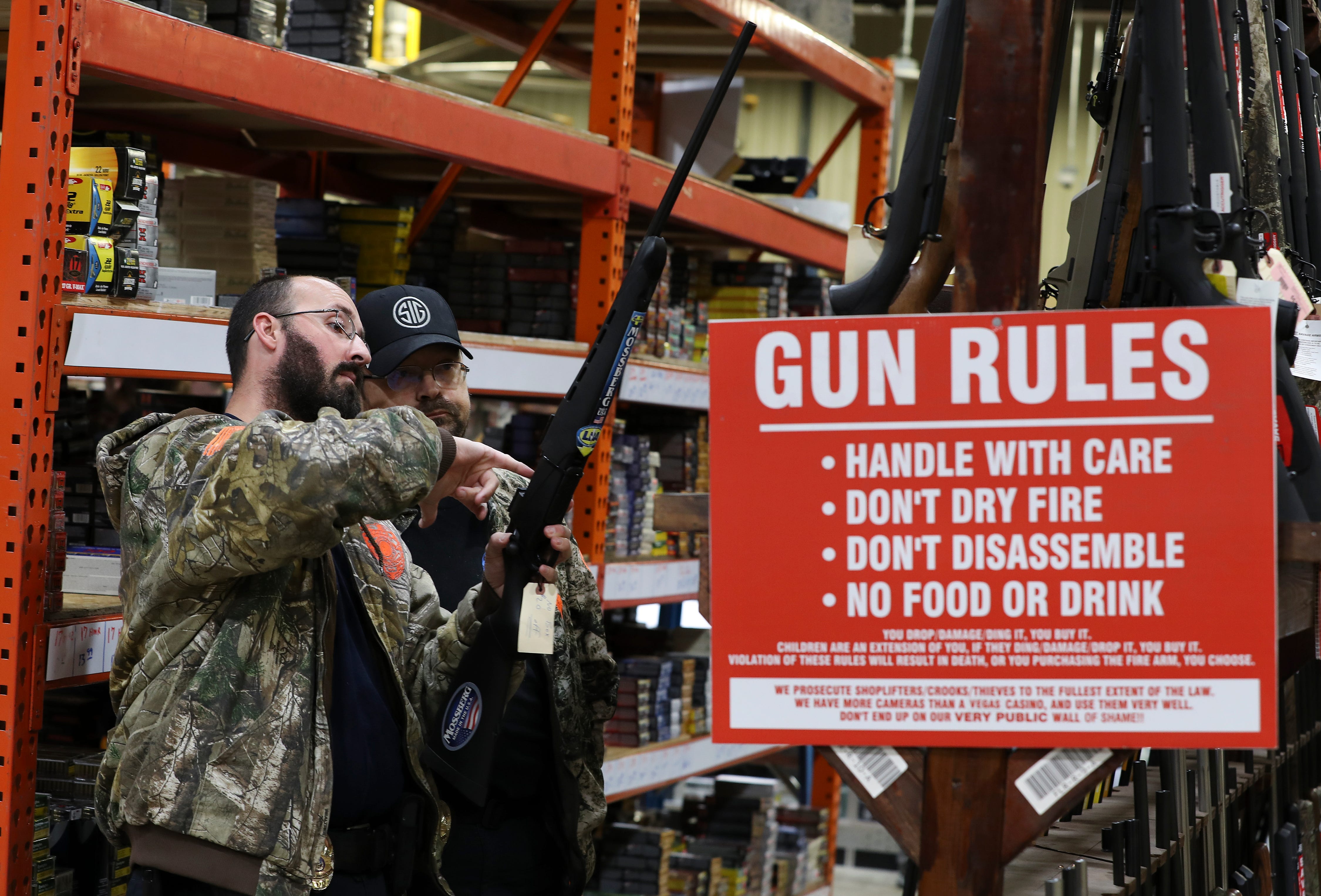 David Downs, left, and Jerry Mills, co-owners of Rocky's Private Protection in Louisville, checked out rifles while shopping at the Kentucky Gun Co. in Bardstown, Kentucky, on March 18, 2020.