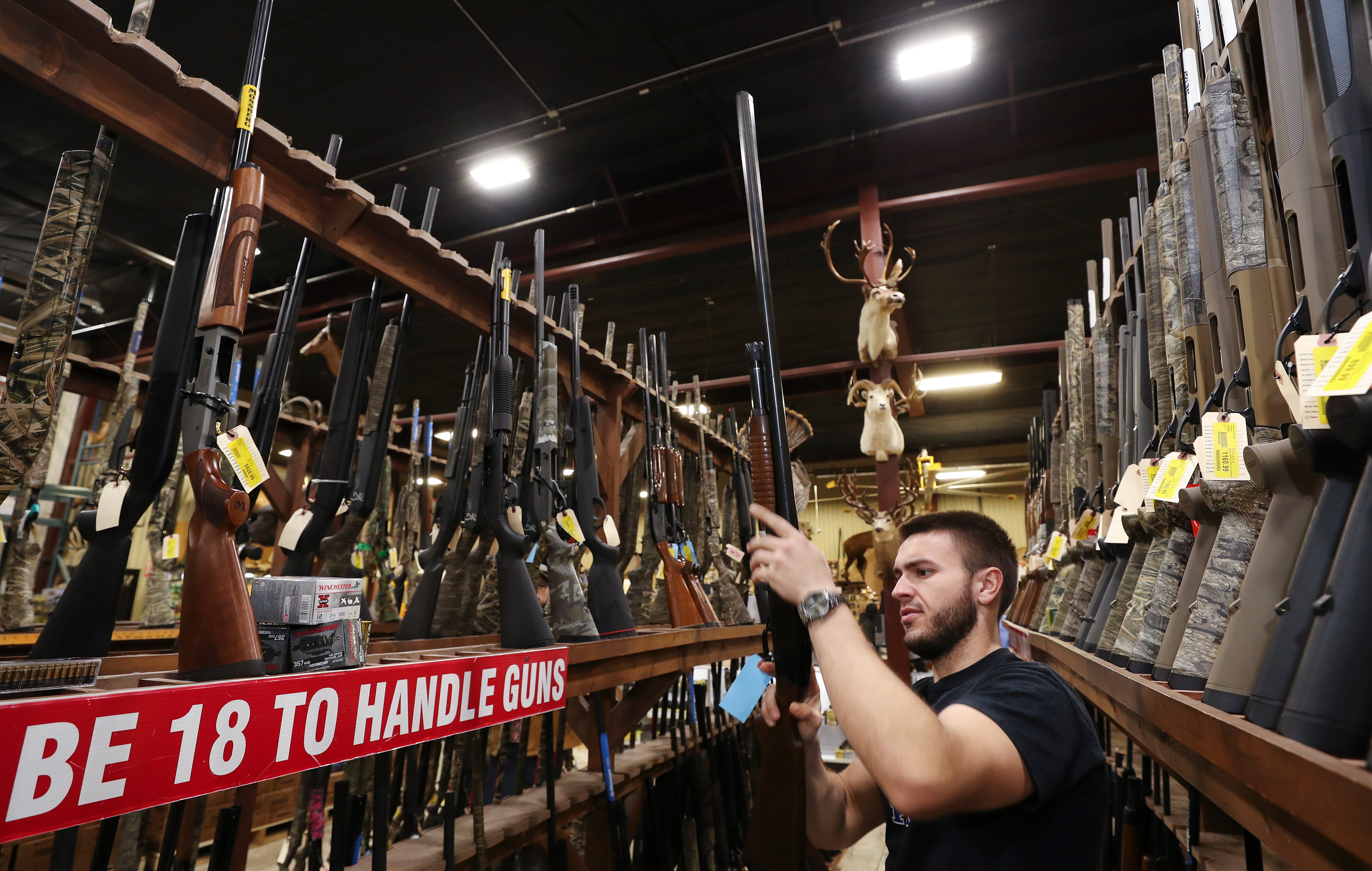 Isaac Hutchins, 22, looks at rifles while shopping at the Kentucky Gun Co. in Bardstown, Kentucky, on March 18, 2020.