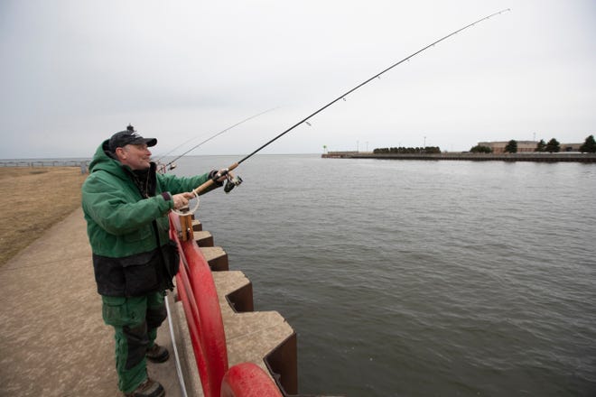 Retired postal worker Jim Dembiec relaxes while fishing near the Milwaukee Harbor entrance Wednesday, March 18, 2020 near the south end of the Summerfest grounds.