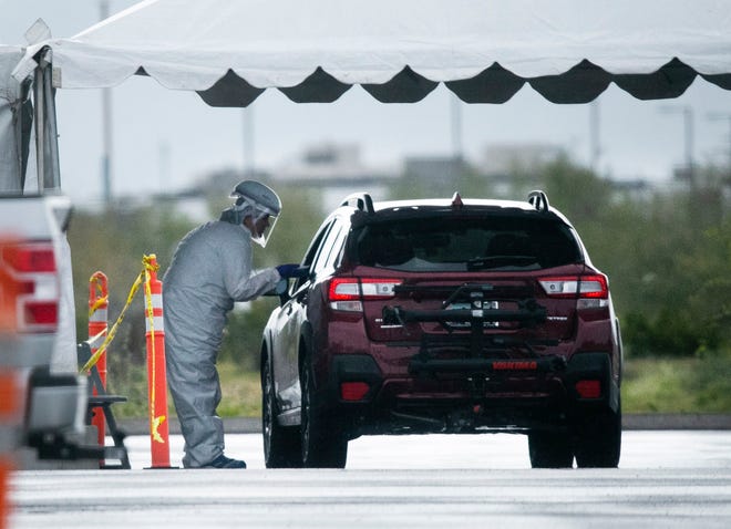 Individuals are tested for COVID-19 at a mobile clinic set up in the parking lot at the Mayo Clinic Hospital in Phoenix on the morning of March 18, 2020.
