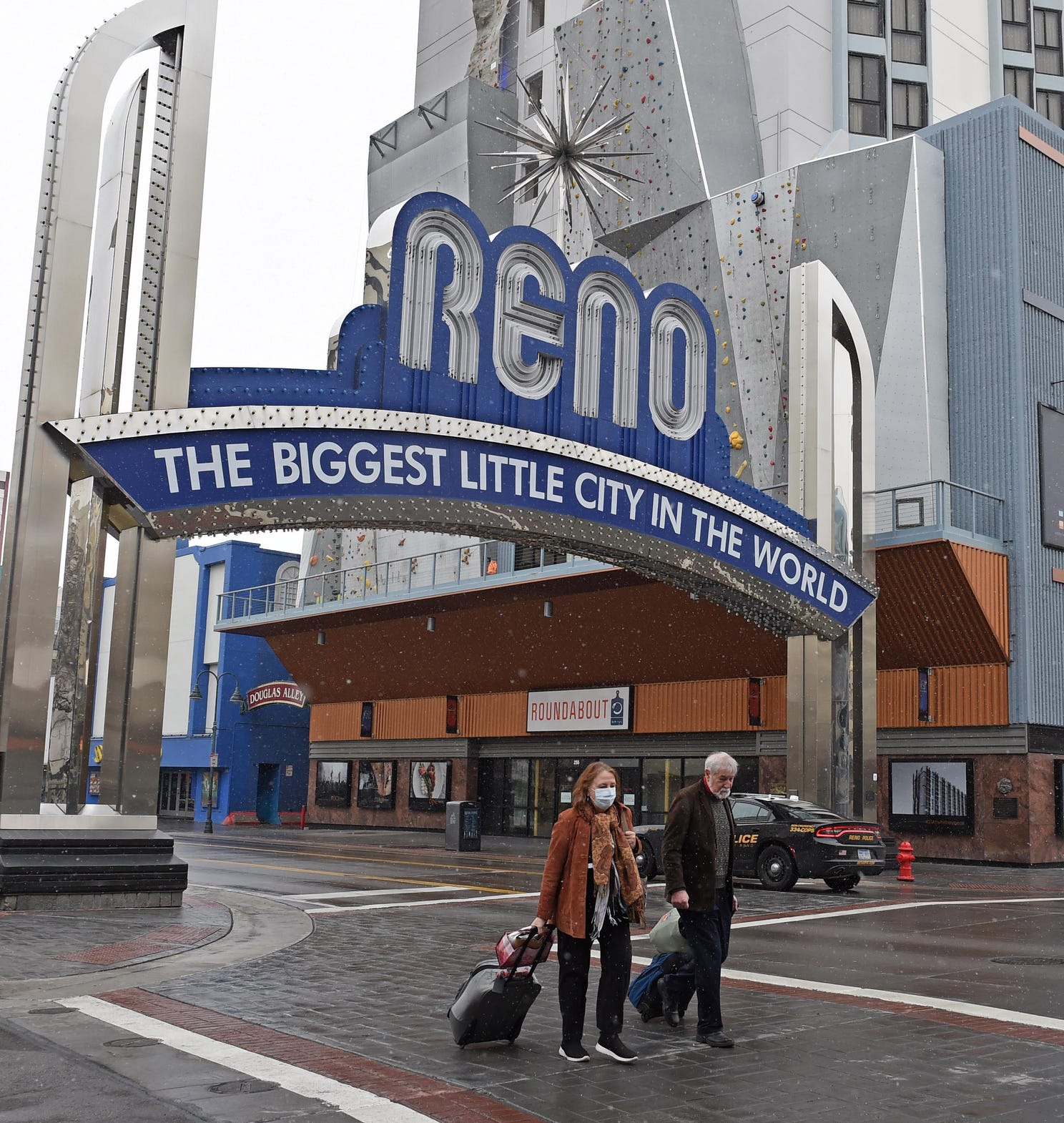 Ted and Chris Champman cross the street in downtown Reno on March 18, 2020. The couple, who is from Florida, was planning on staying in Reno two days, but they had to leave after their first night.