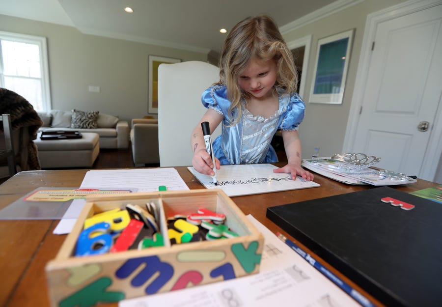 Paige Klein, 4, does schoolwork in the dining room of her family's home in Bedford, N.Y. March 18, 2020. Students of all ages have started schooling at home as schools have closed due to coronavirus concerns.  