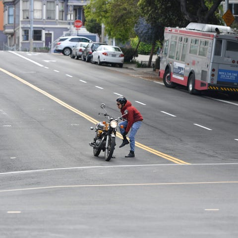 A motorcyclist adjusts his pants from the middle o