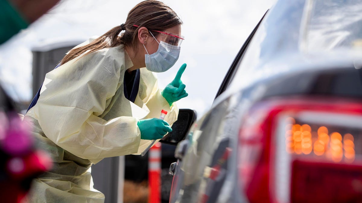 Ashley Layton, an LPN at St. Luke's Meridian Medical Center, communicates with a person before taking a swab sample at a special outdoor drive-thru screening station for COVID-19   coronavirus in Meridian, Idaho on March 17, 2020.
