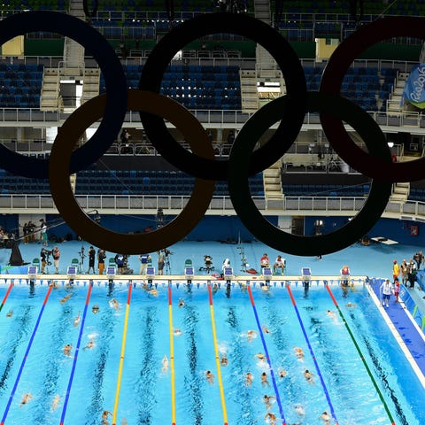Swimmers train under the Olympic rings at the 2016