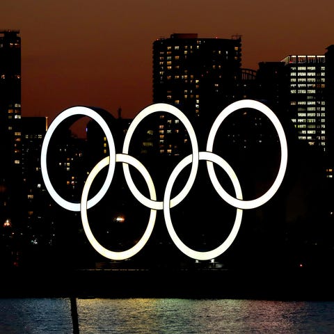 The sun sets behind the Olympic rings installation