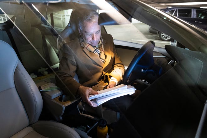 Because he just returned from a week-long trip to California, attorney Michael Sperling works from his car Friday, March 20, 2020 in the parking ramp of the 100 East Wisconsin Building in Milwaukee, Wis. His office is in the building, and working in the parking ramp allows his legal assistant to bring him papers he needs to sign, coffee and other items.